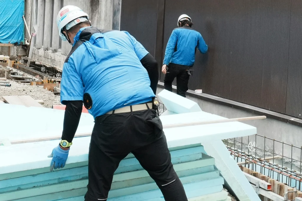 Illustrative workers handling foam insulation boards, not McGill’s staff or a project